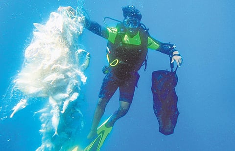 An underwater view of one of the community divers retrieving ghost nets which had trapped mackerel fish | Express