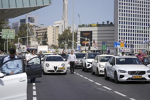 Israelis stand still next to their cars on a main road as a two-minute siren sounds in memory of victims of the Holocaust in Tel Aviv. (Photo | AP)