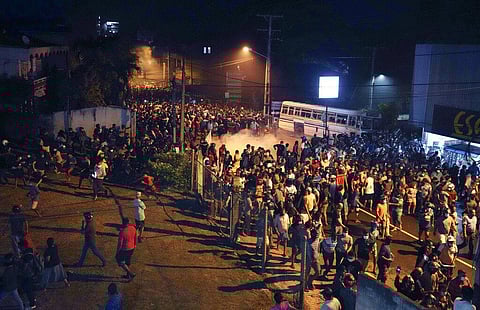 Protesters run to take cover as police uses tear gas shells to disperse them during a protest outside Sri Lankan president's private residence on the outskirts of Colombo(Photo |AP)