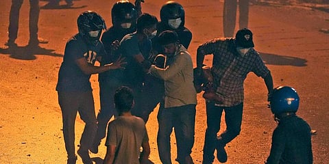 Sri Lankans carry a wounded protester during a protest outside Sri Lankan President Gotabaya Rajapaksa's private residence on the outskirts of Colombo, Sri Lanka. (Photo | AP)