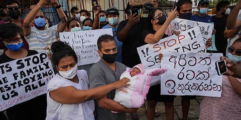 A Sri Lankan couple with their infant join an anti government protest during a curfew in Colombo. (Photo | AP)