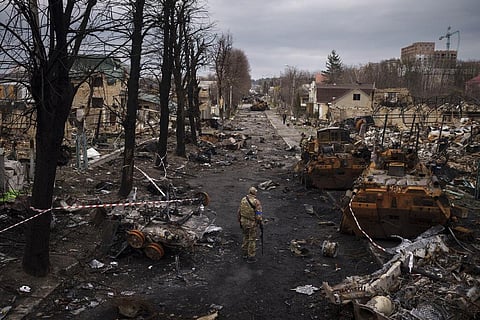 A Ukrainian serviceman walks amid destroyed Russian tanks in Bucha, on the outskirts of Kyiv, Ukraine, April 6, 2022. (Photo | AP)