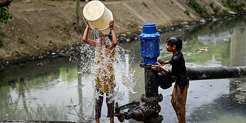 Children play with water to beat the heat on a hot summer afternoon, in New Delhi. (Photo | PTI)