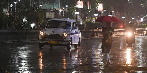Vehicles move slowly on the city street during sudden rain in Kolkata. (Photo| PTI)