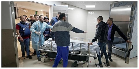 Journalists and medics wheel the body of Shireen Abu Akleh, a journalist for Al Jazeera network, into the morgue inside the Hospital in the West Bank town of Jenin. (Photo |AP)