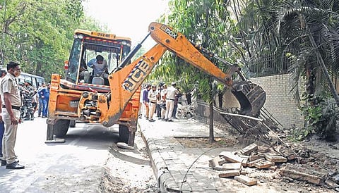 A bulldozer razes a structure during an anti-encroachment drive by the Municipal Corporation (North) at Vasant Kunj on Tuesday | shekhar yadav