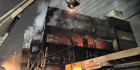 Firefighters try to douse a fire which broke out in a building at Mundka, in West Delhi. (Photo| PTI)