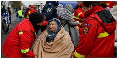 Emergency Situations Department employees talk to wheelchair bound Katia, 90 years-old, a refugee fleeing the conflict from neighbouring Ukraine at the Romanian-Ukrainian border, in Siret, Romania.