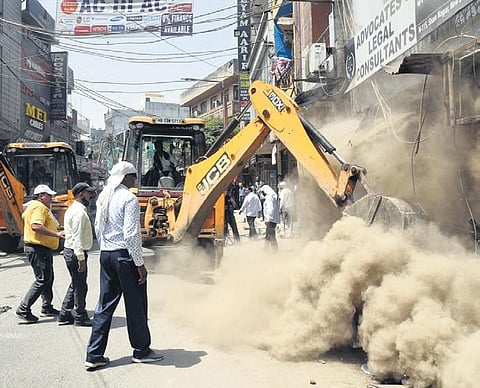 Municipal corporation workers use bulldozers to demolish structures during an anti-encroachment drive at Shyam Nagar in Khayala on Friday. (Photo | Parveen Negi/EPS)