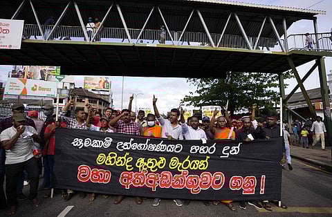 Members of Socialist Youth Union shout slogans and march towards Sri Lanka's police headquarters carrying a banner demanding the arrest of former prime minister Mahinda Rajapkasa. (Photo | AP)