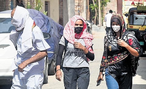People cover themselves on a hot sunny day at Connaught Place | parveen negi