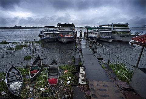 A man walks holding an umbrella near anchored boats as it rains in Kochi, Kerala state, India, Tuesday, May 17, 2022. (Photo | AP)