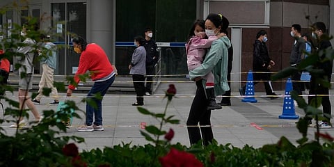 Residents wearing masks line up for mass Covid testing on Tuesday, in Beijing. (Photo | AP)