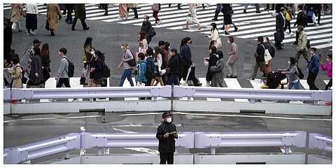 People wearing protective masks to help curb the spread of the coronavirus walk along a pedestrian crossing on April 20, 2022, in Tokyo. (Photo |AP)