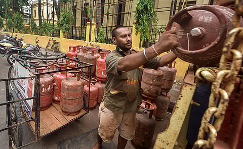 A worker unloads domestic LPG gas cylinders from a truck, in Kolkata. (Photo | PTI)