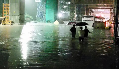 People wade through knee-deep water near Silk Board Junction after heavy rain lashed Bengaluru. (Photo | Express)
