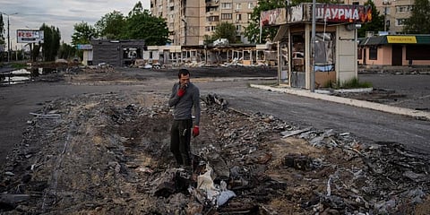 A man searches for metal scraps in a shelled neighbourhood in Ukraine. (Photo | AP)