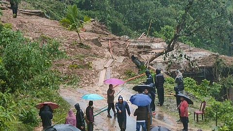 People stand near a landslide hit area following heavy rainfall in Dima Hasao district of Assam. (Photo | PTI)