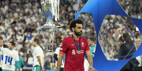 Liverpool's Mohamed Salah, wearing his second place medal. walks past the trophy after the 2022 Champions League final.(Photo | AP)
