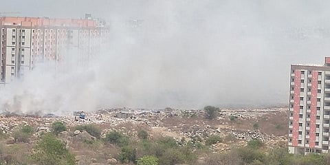 An illegal dumpyard in Nizampet has been burning for the last 4 weeks right beside government's 2BHK housing which are yet to be handed out to beneficiaries. (Photo| EPS)