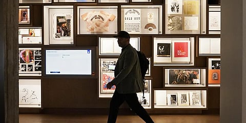 A man walks past a portion of the archive wall at the Bob Dylan Center, Thursday, May 5, 2022, in Tulsa.(Photo | AP)