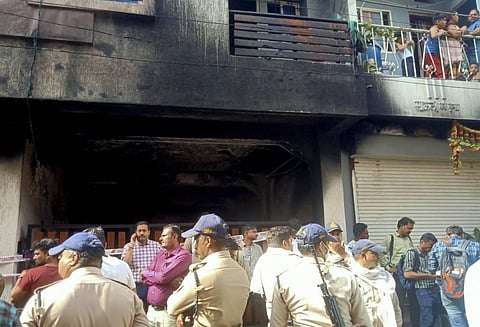 Police personnel stand guard after a fire broke out in a building, in Indore, Saturday, May 7, 2022. (Photo | PTI)