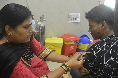 A health worker administers a booster dose of COVID-19 vaccine to beneficiaries in Bengaluru on Friday. (Photo | EPS)