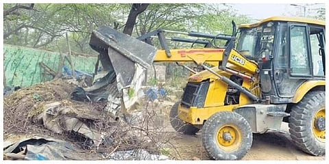 A bulldozer removes first phase of the drive at Karni Singh Shooting Range in Tughlaqabad on Wednesday | EXPRESS