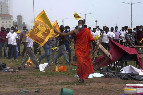 A Buddhist monk joins other government supporters in vandalizing the site of anti-government protests outside the president's office in Colombo, Sri Lanka. (Photo | AP)