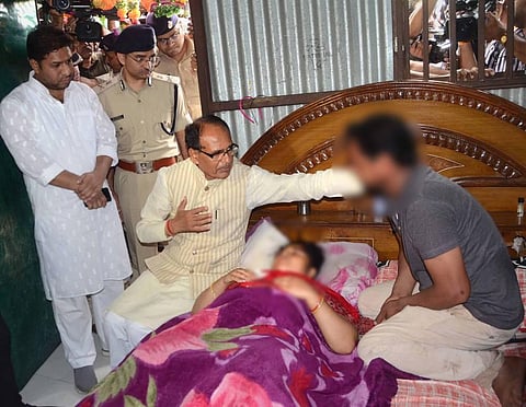 Madhya Pradesh Chief Minister Shivraj Singh Chouhan meets the woman who was allegedly attacked with a blade after she was harassed by some miscreants. (Photo | PTI)