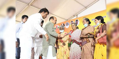 Chief Minister Basavaraj Bommai hands over a certificate to a woman during his inspection of development works in the city | Express