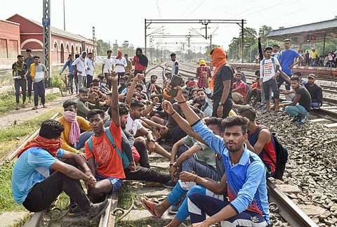 Youngsters sit on railway tracks to protest against the 'Agnipath' scheme, in Buxar, Wednesday, June 15, 2022. (Photo | PTI)