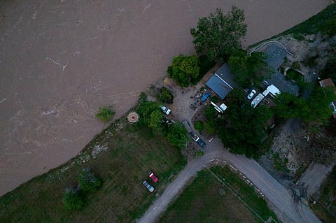 The roaring Yellowstone River is seen from the air sweeping over trees and near homes. (Photo | AP)