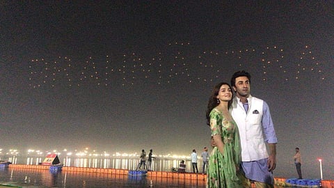 Actors Alia Bhatt and Ranbir Kapoor pose as drones form the words Brahmastra on the night sky at the Kumbh Mela on Maha Shivaratri. (Photo | Dharma Productions Instagram)