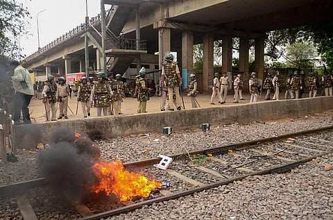 Police personnel inspect railway properties, that were vandalised and set on fire by miscreants during a protest against the 'Agnipath' scheme. (Photo | PTI)