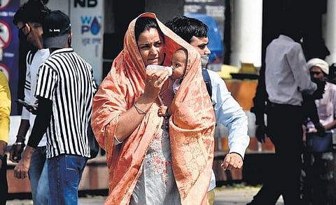 People protect themselves from the heat at Connaught Place. (Photo | EPS)