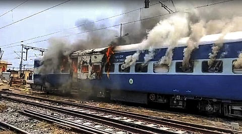 Smoke billows out after youngsters set on fire a train in protest against the 'Agnipath' scheme at Chapra railway station, in Saran district. (Photo | PTI)