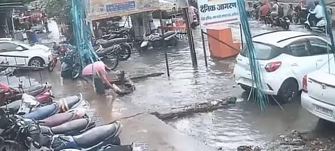 A screengrab from the video showing a couple on a scooter fall into what appears to be a waterlogged ditch in Aligarh, Uttar Pradesh.