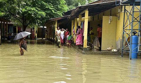 Villagers at a partially submerged flood relief camp in a flood-affected area after heavy rains, in Nalbari district, Sunday. (Photo | PTI)