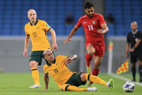 Jordan's Mousa Suleiman right, and Australia's Alan Davidson fight for the ball during a friendly soccer match between Jordan and Australia in Doha, Qatar. (Photo | AP)