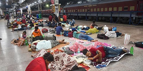 Passengers take shelter at Patna railway station after several trains were cancelled due to protests against Centre's 'Agnipath' scheme, in Patna. (Photo | PTI)