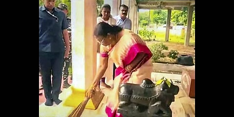 NDA presidential candidate Droupadi Murmu sweeps the floor of a Shiva temple in her locality(Photo | PTI)