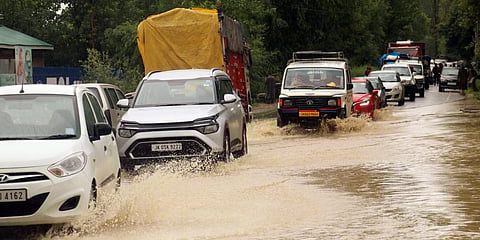 Vehicles ply on waterlogged roads due to heavy rainfall, at the Baramulla-Srinagar National highway, in Baramulla. (Photo| ANI)