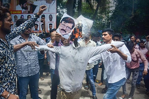 Supporters of rebel Shiv Sena leader Eknath Shinde burn an effigy during a demonstration amid political crisis in the state, outside Thane Municipal Corporation. (Photo | PTI)