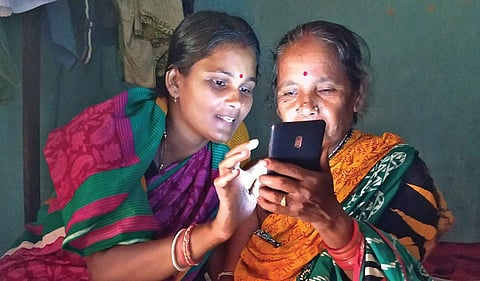 A digital ‘sathi’ teaches how to handle a smartphone. (File photo )