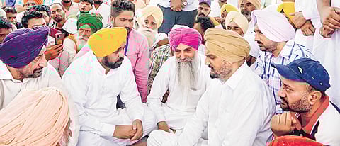 Bhagwant Mann with Balkaur Singh, father of Sidhu Moosewala, at Musa village on Friday | PTI