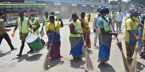 Coimbatore City Municipal Corporation workers clean a bus stand. (Photo| EPS)