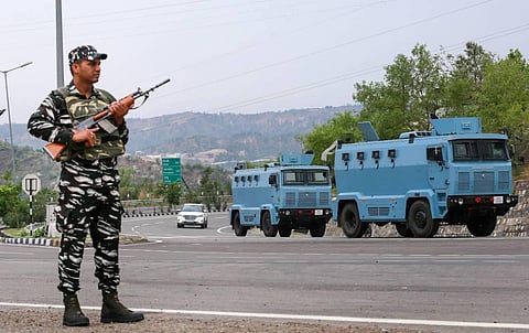 A CRPF personnel stands guard at the Jammu-Srinagar National Highway as security convoy leaves for Kashmir in preparation for the 'Amarnath Yatra', in Jammu. (Photo | PTI)