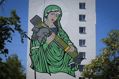 A mural depicts an image known as 'Saint Javelina'- Virgin Mary cradling a US-made FGM-148 anti-tank weapon Javelin - on a living house wall in Kyiv, Ukraine. (Photo | AP)