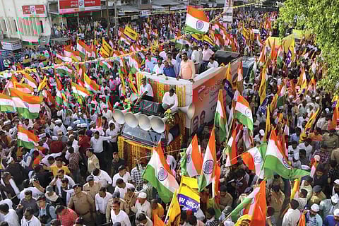 Delhi Chief Minister and AAP Convener Arvind Kejriwal waves at the supporters during the party's ‘'Tiranga Yatra'’ cum roadshow, in Mehsana. (Photo | PTI)